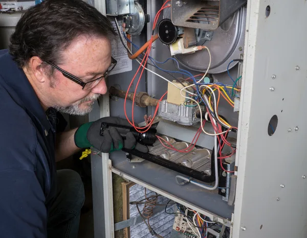 Greers Ferry Heat & Air technician servicing a gas furnace