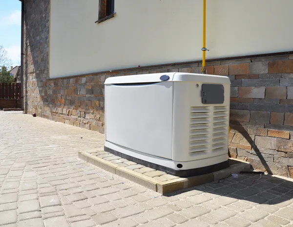 Greers Ferry Heat & Air technician installing a whole home standby generator outside a residence
