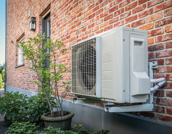 Greers Ferry Heat & Air technician installing an outdoor heat pump condensing unit