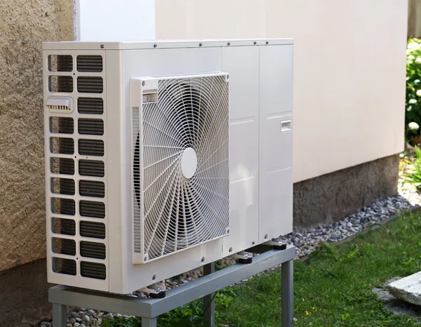 Greers Ferry Heat & Air technician performing maintenance on an outdoor heat pump unit