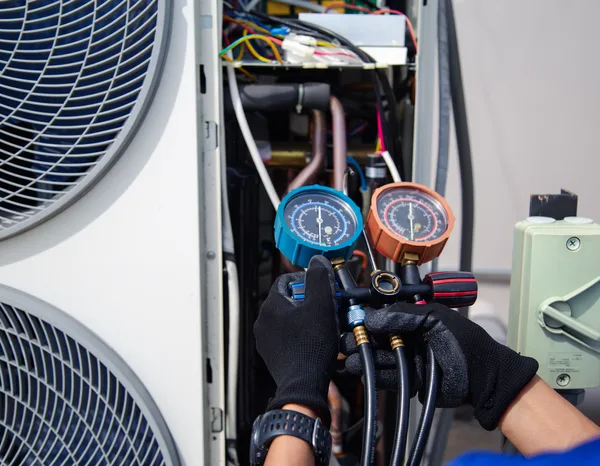 Greers Ferry Heat & Air technician performing maintenance on a rooftop package unit