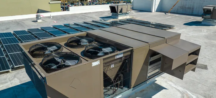Greers Ferry Heat & Air technician inspecting and diagnosing a rooftop package unit