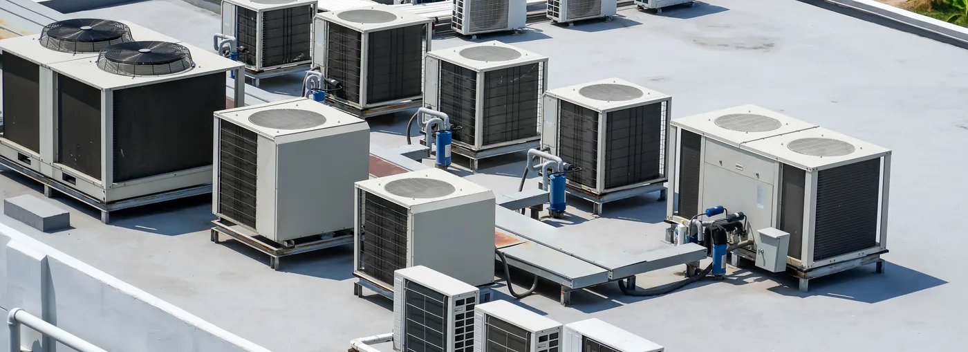 Rows of commercial rooftop HVAC units on a flat commercial roof in central Arkansas