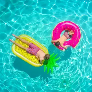 Aerial view of a swimming pool with two boys on floating toys