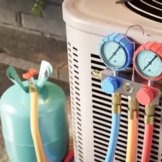 A tech from Greers Ferry Heat & Air tests the refrigerant in this AC
