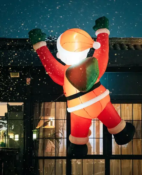 A giant inflatable Santa Clause hangs from the roof.